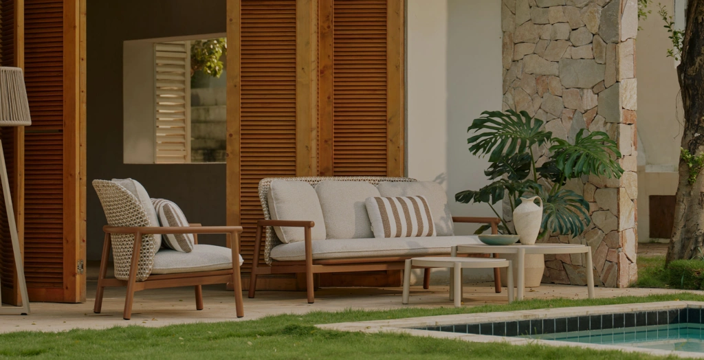 Lille lounge armchair, 3-seat sofa and ceramic coffee tables on a terrace beside a pool, with louvered wooden shutters behind